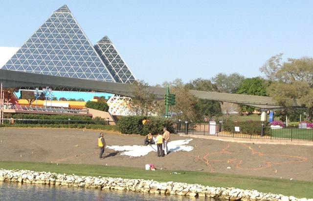 They have LARGE cut-outs that they place in the right place and then they spray paint the outline directly onto the soil - the stakes and flags are still there to help later on