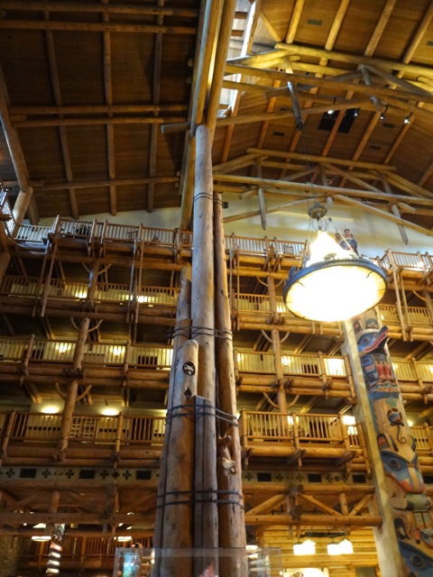 The center pole is Disney-wood (i.e. steel structural support imagineered to look like wood), it is surrounded by carved lodge pole pine. There is an animal carved atop each pole.