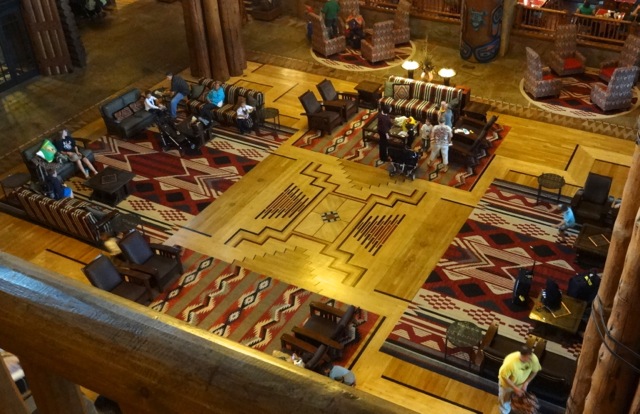 Looking down at the lobby from the 5th floor... There are lightning bolts coming off of each of the four lodge pole clusters, they come together in the center to represent the cosmos. The two pale triangles represent nature and the two red & brown triangles represent mankind.